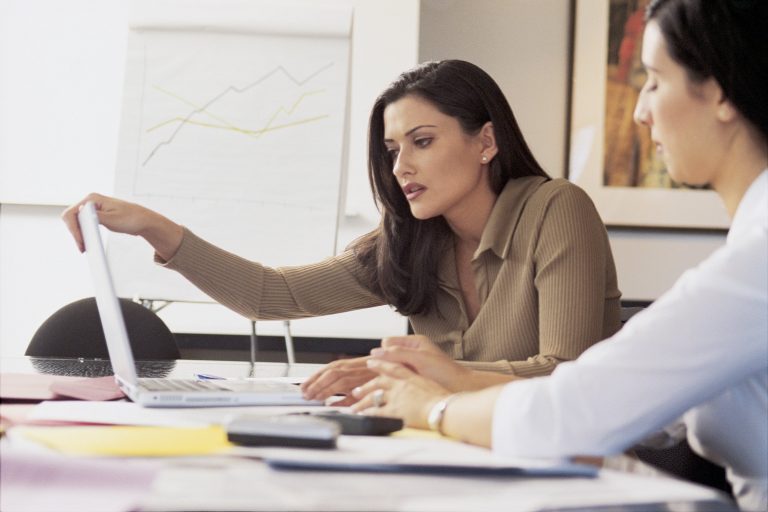 Woman holding top of laptop screen looking concerned