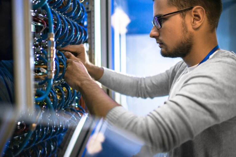 Side View Portrait Of Young Man Wearing Glasses Connecting Cables