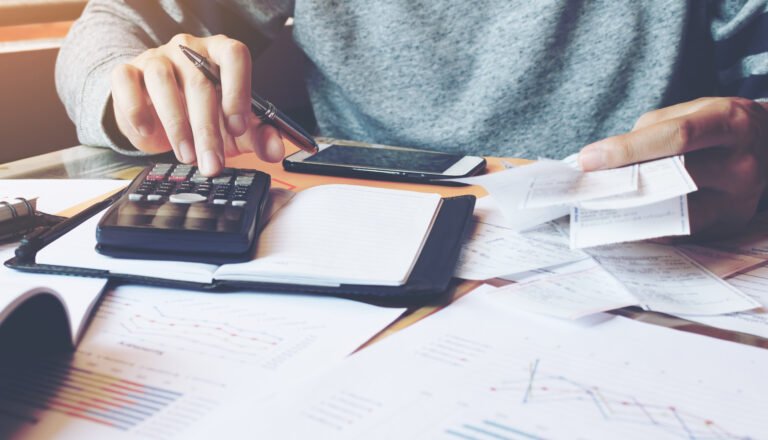 Man Using Calculator And Calculate Bills In Home Office