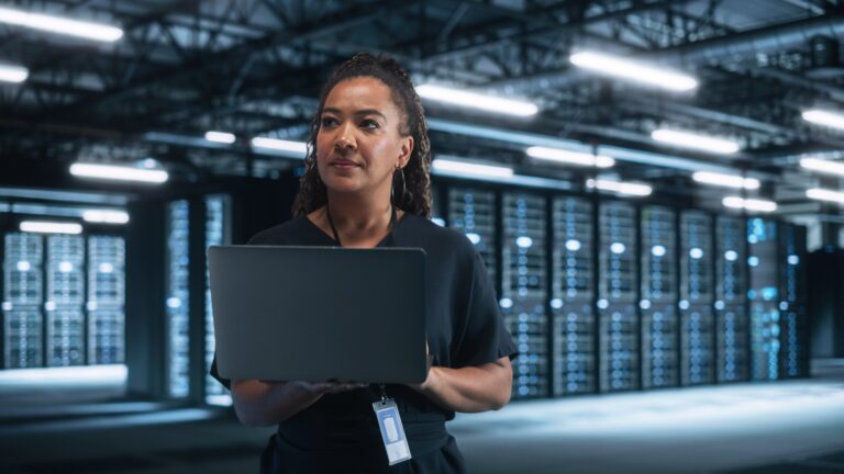 Portrait Of Successful African American Female IT Specialist Using Laptop