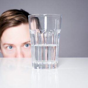 Person looking at a half full glass of water